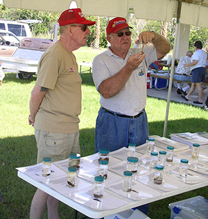 photo of 2 lakewatch volunteers looking a various samples of water on a table