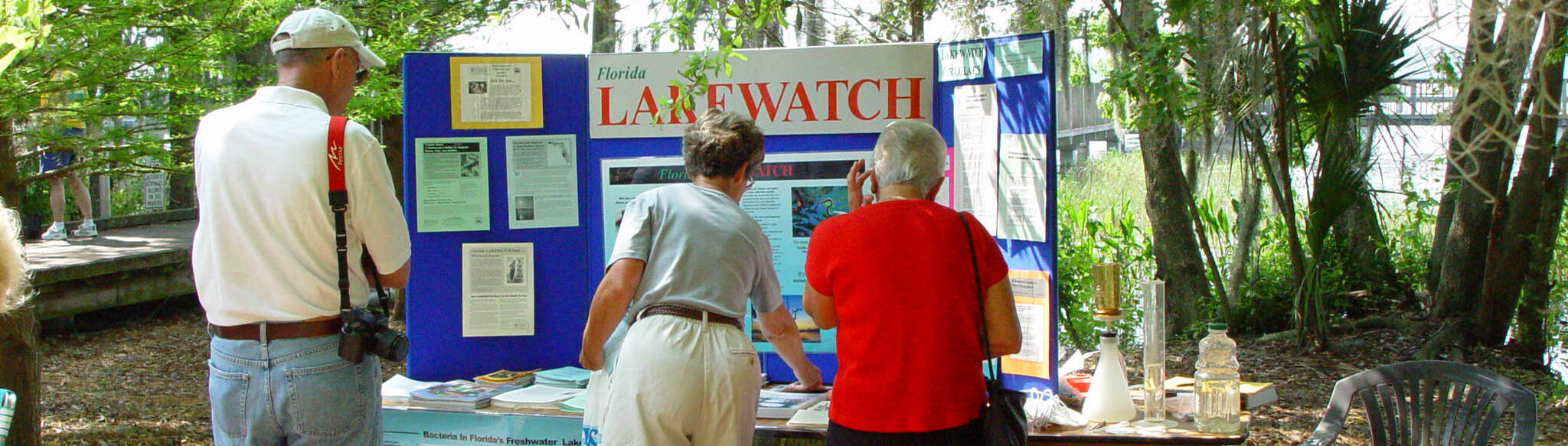 photo of people looking at a Lakewatch booth at a community event